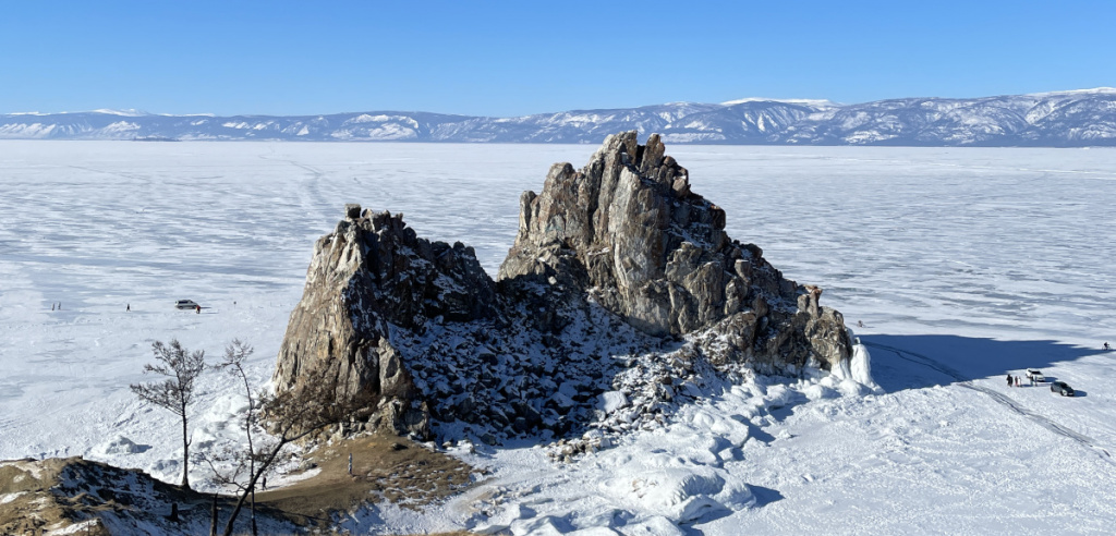 Люди гуляют на льду на берегу Байкала. 